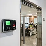 Reader fingerprint ZKTeco terpasang di pintu kantor modern
