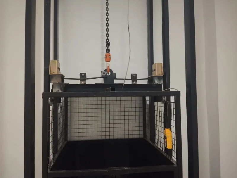 Detail mekanisme lift barang: electric chain hoist, rantai baja, dan limit switch