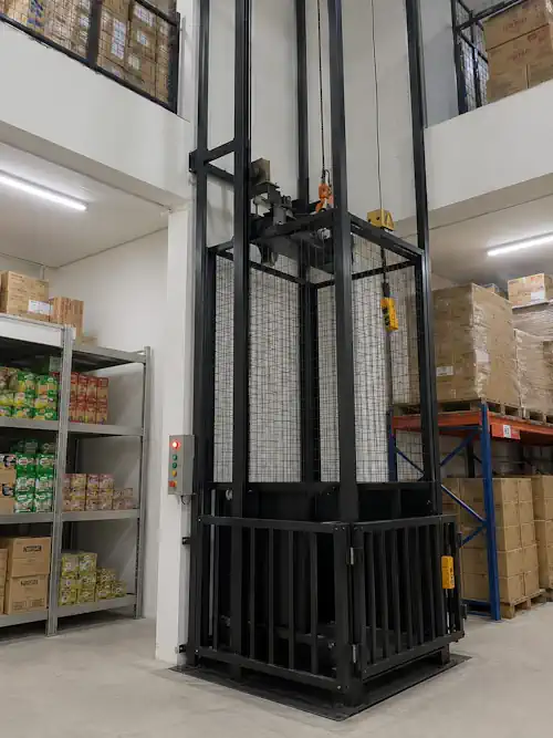 Lift barang custom terpasang di ruko grosir Jakarta Utara, tampak rangka baja hitam dan sangkar mesh