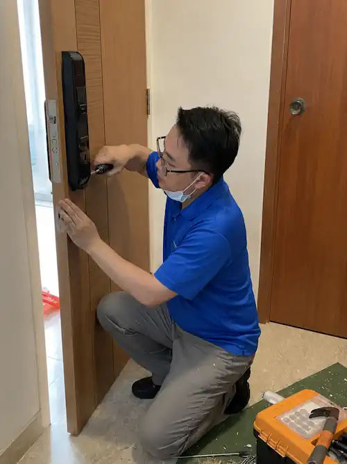 Teknisi Titantek memasang smart lock Onassis di pintu hunian