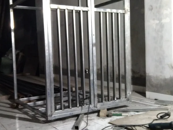 Lift barang baja terpasang di ruko dengan platform dan pintu geser