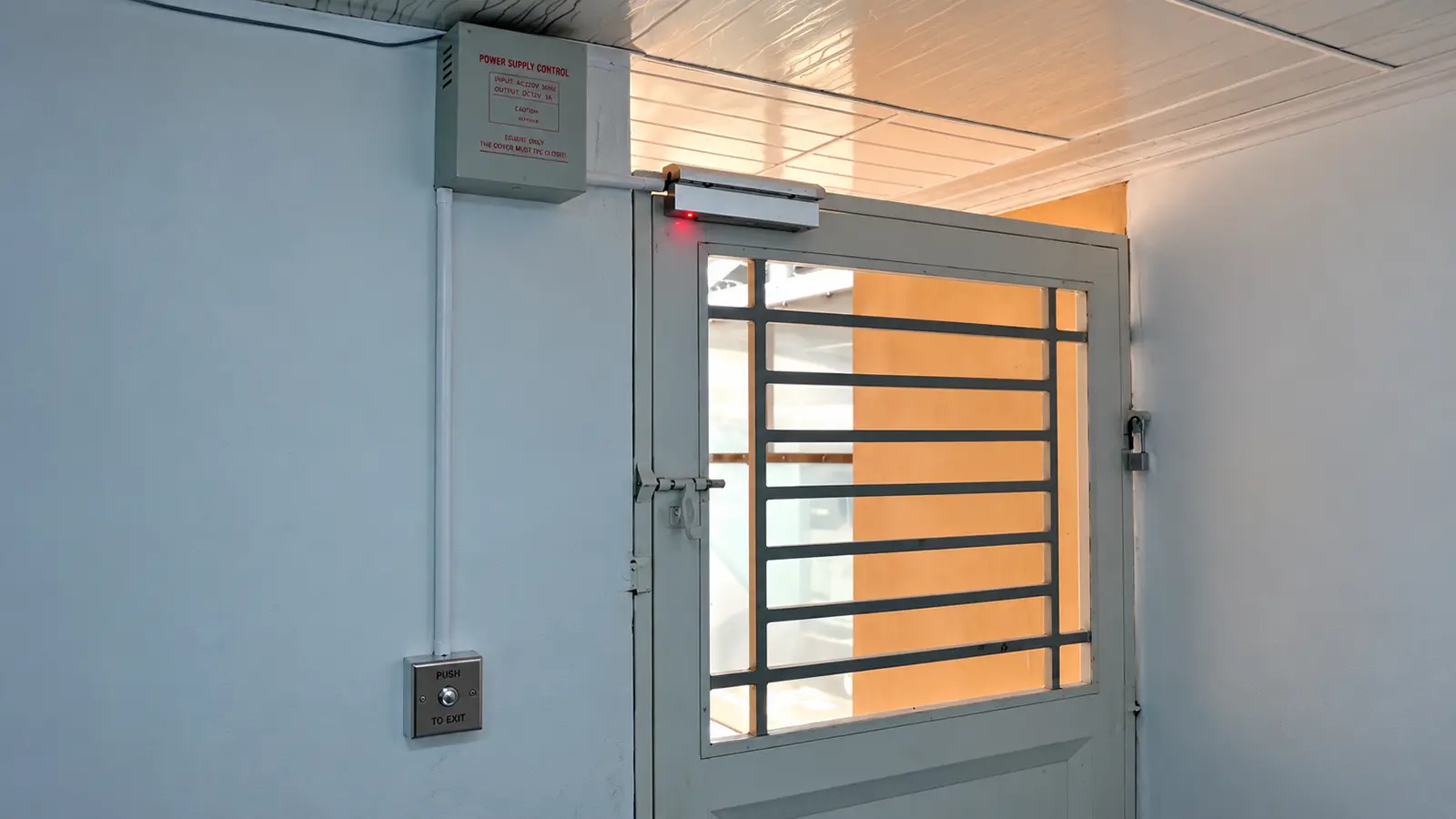Sisi dalam pintu di Jl. Bunga Asoka Medan dengan magnetic lock di atas kusen, boks power supply 12V, dan exit push button di dinding