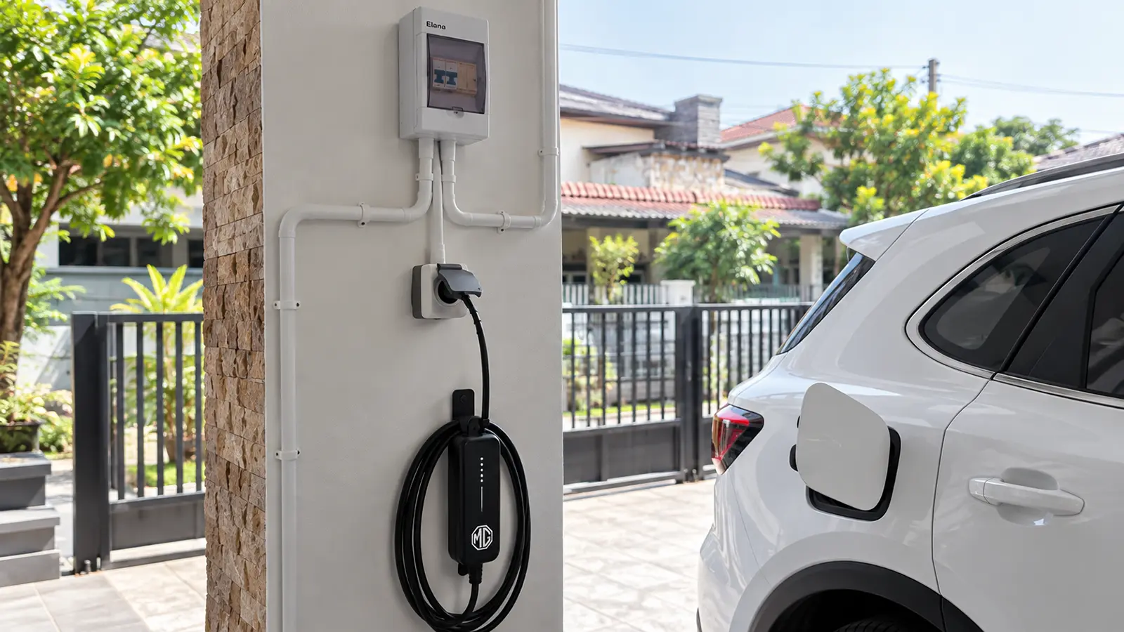 Colokan waterproof bertutup untuk portable charger mobil listrik di tiang carport rumah di Medan, dengan box MCB di atasnya dan mobil listrik terparkir di sampingnya